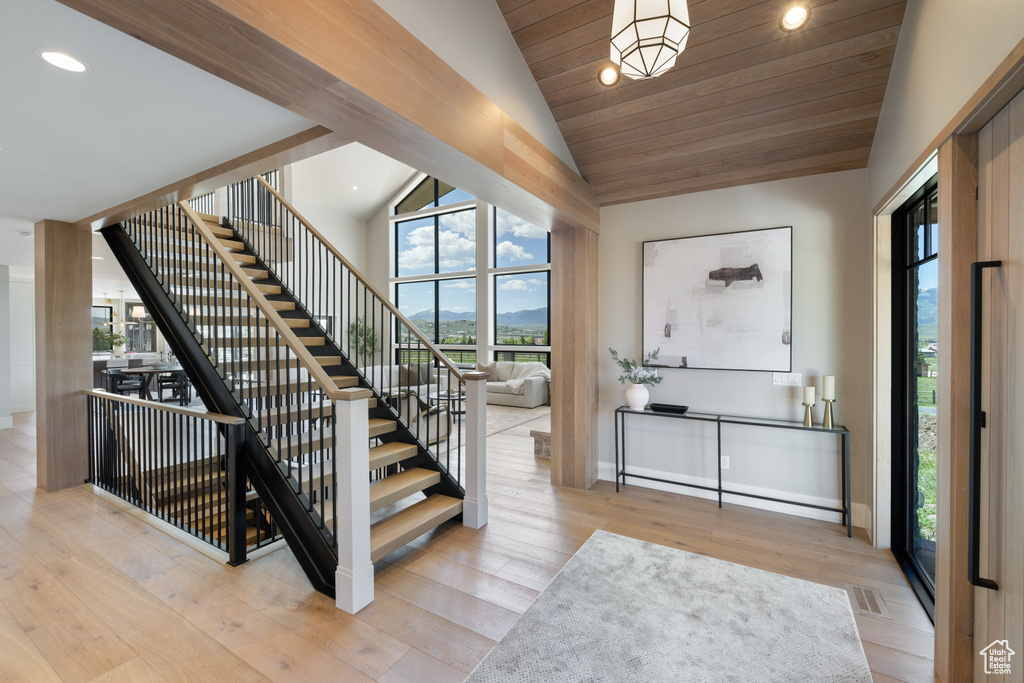 Entryway featuring vaulted ceiling, stairway, recessed lighting, and wood finished floors