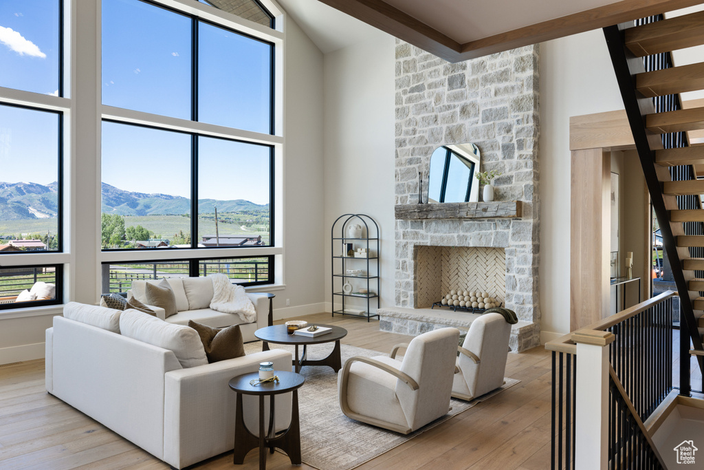 Living area featuring wood-type flooring, a mountain view, a towering ceiling, and a fireplace