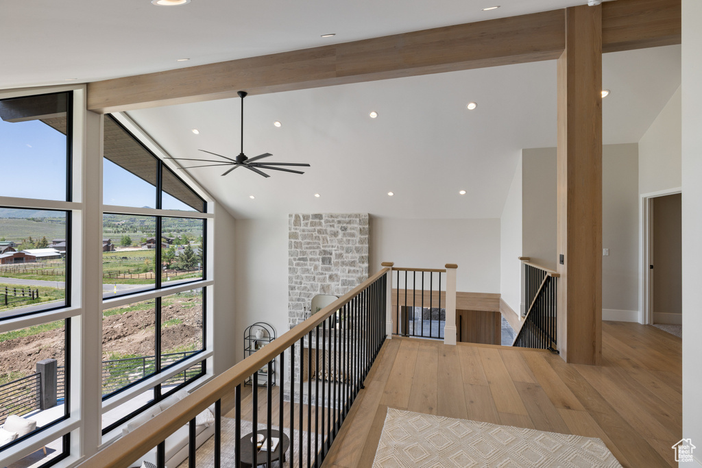 Corridor with an upstairs landing, wood finished floors, beamed ceiling, high vaulted ceiling, and recessed lighting
