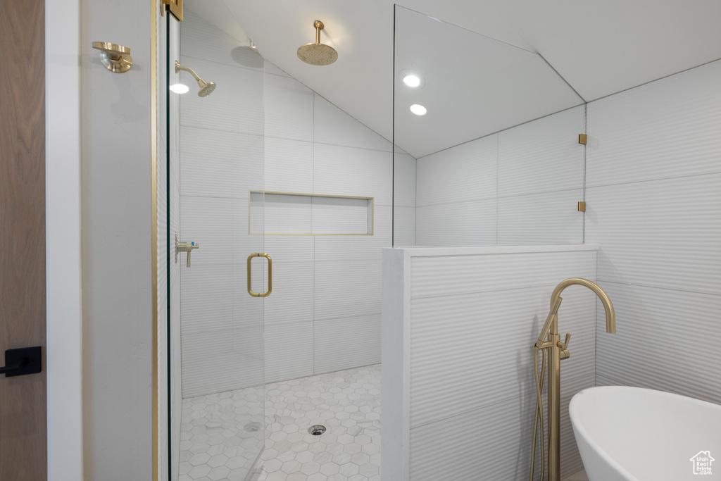 Bathroom featuring vaulted ceiling, a stall shower, a soaking tub, and recessed lighting