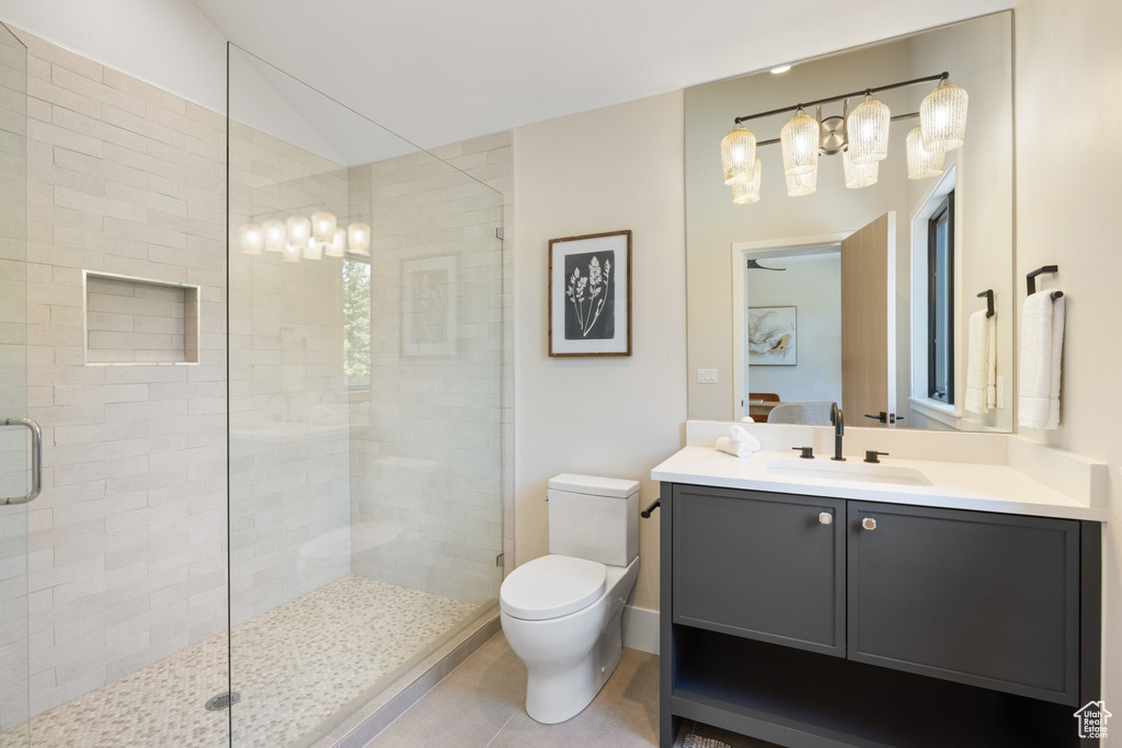 Bathroom featuring a stall shower, vanity, and vaulted ceiling