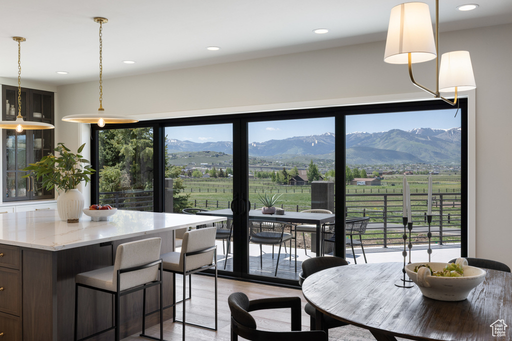 Dining area with a view of countryside, a mountain view, light wood-style flooring, and recessed lighting