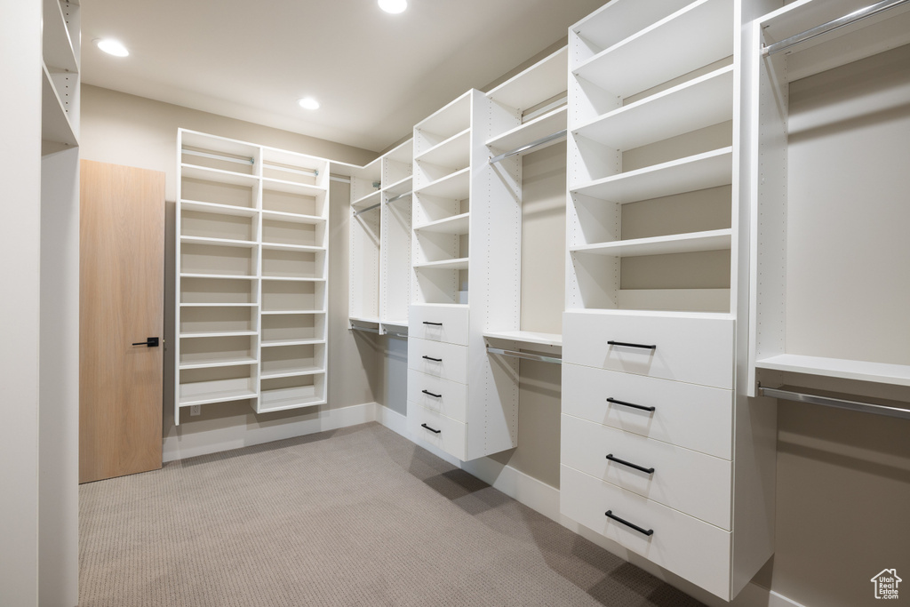 Walk in closet with light colored carpet