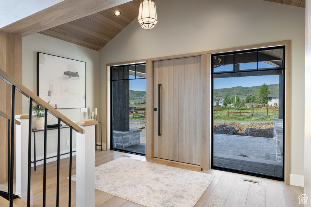 Entrance foyer with vaulted ceiling, wood finished floors, wood ceiling, a mountain view, and recessed lighting