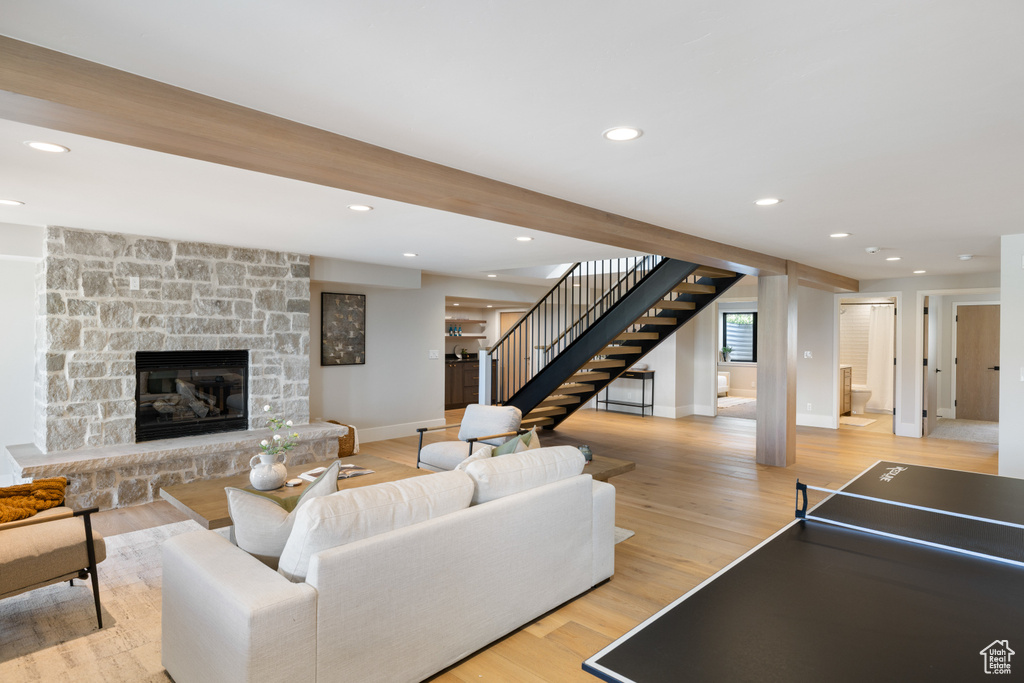 Living area featuring stairway, light wood-style floors, recessed lighting, and a stone fireplace