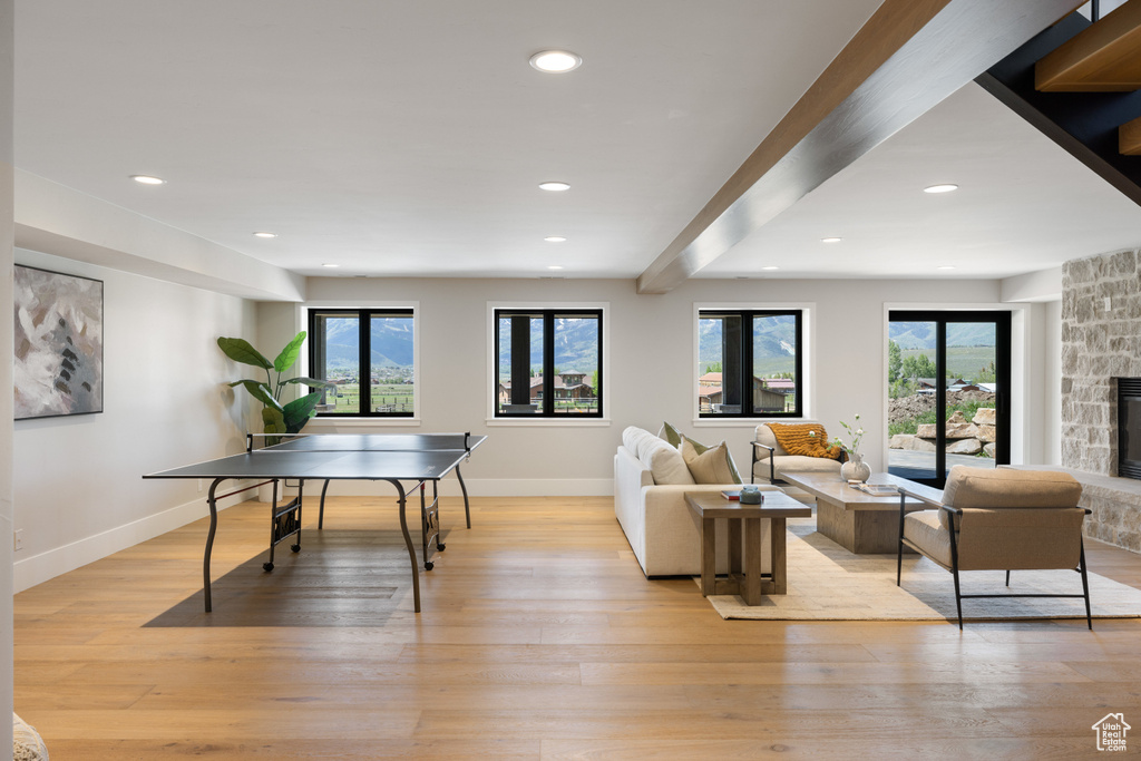 Rec room featuring healthy amount of natural light, light wood-style floors, recessed lighting, and a fireplace