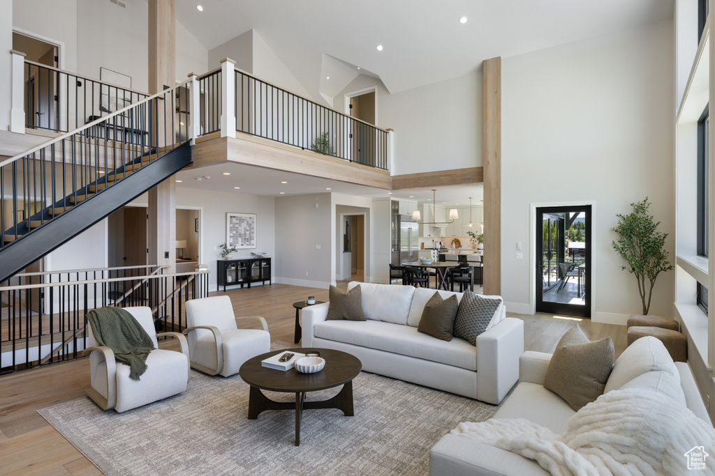 Living room with a high ceiling, wood finished floors, and stairway