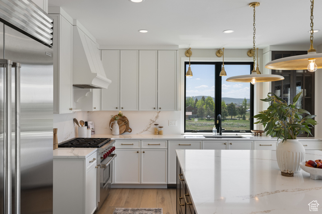 Kitchen featuring high end appliances, recessed lighting, and white cabinets