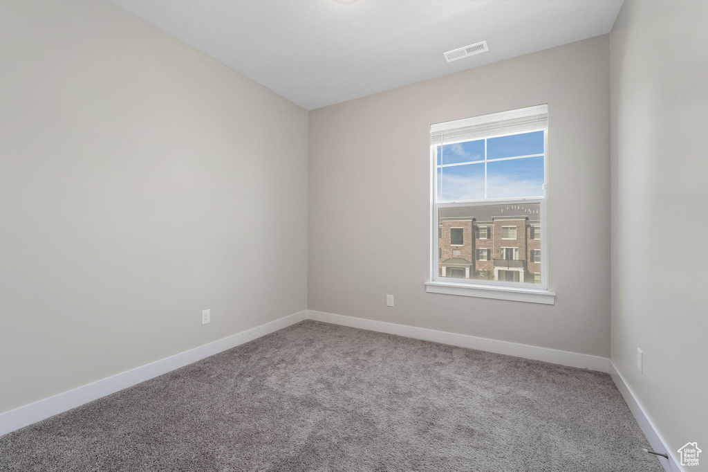 Carpeted empty room with baseboards