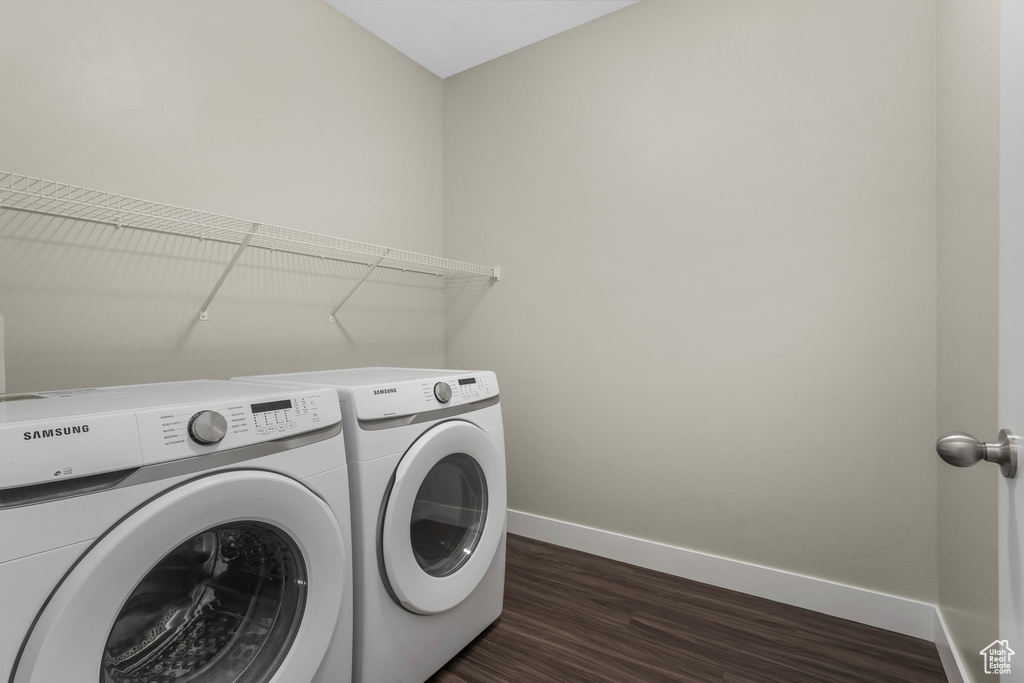 Washroom featuring washer and clothes dryer and dark wood finished floors