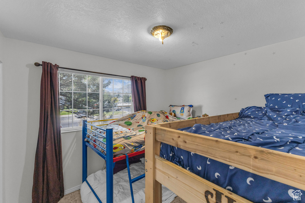 Bedroom with carpet and a textured ceiling