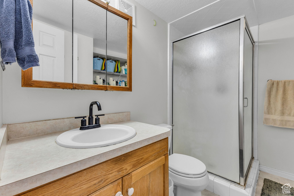 Full bath featuring vanity, a shower stall, and tile patterned floors