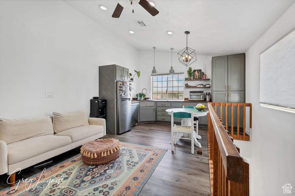 Living area featuring dark wood-type flooring, a ceiling fan, and recessed lighting