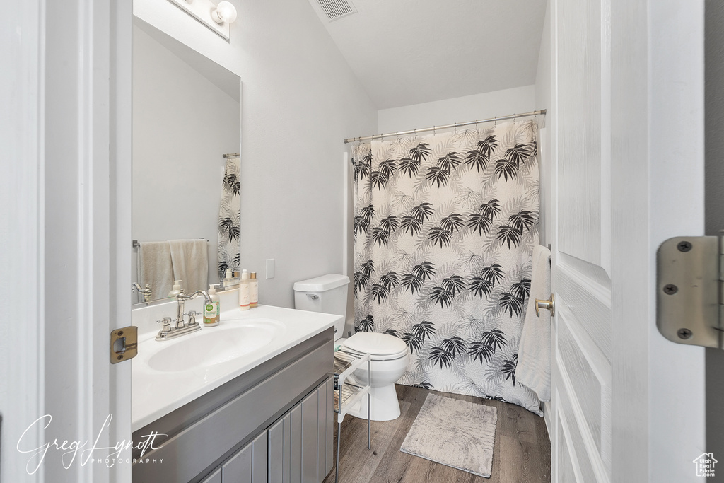 Full bath with vanity, wood finished floors, and a shower with curtain