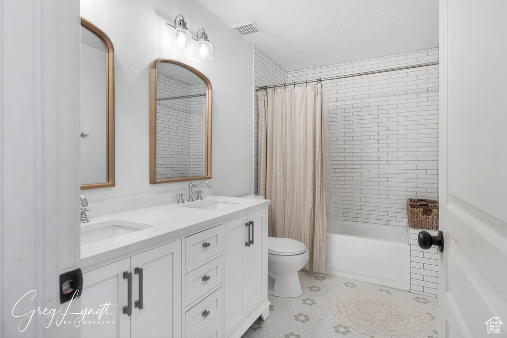 Full bath with double vanity and shower / tub combo with curtain
