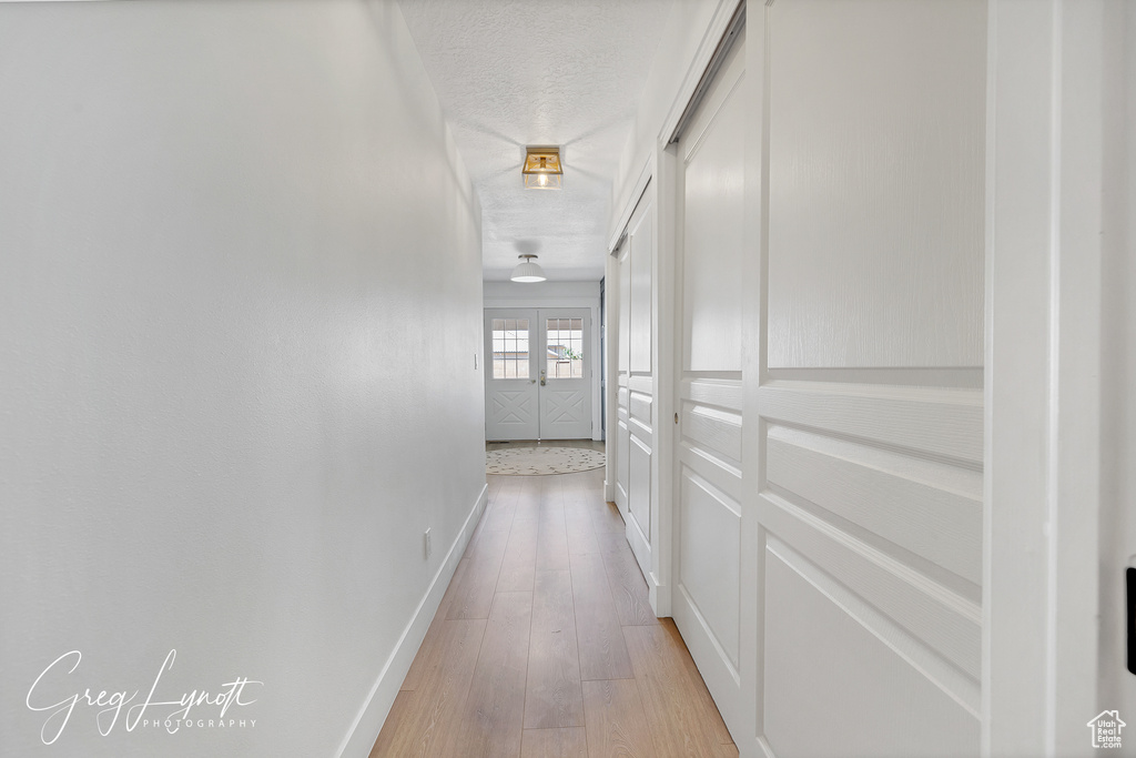Hall with baseboards and light wood-style flooring