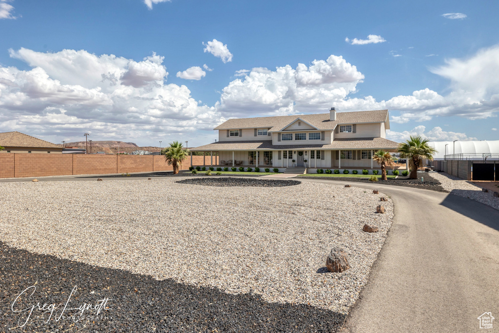 View of front of property with covered porch and roof with shingles