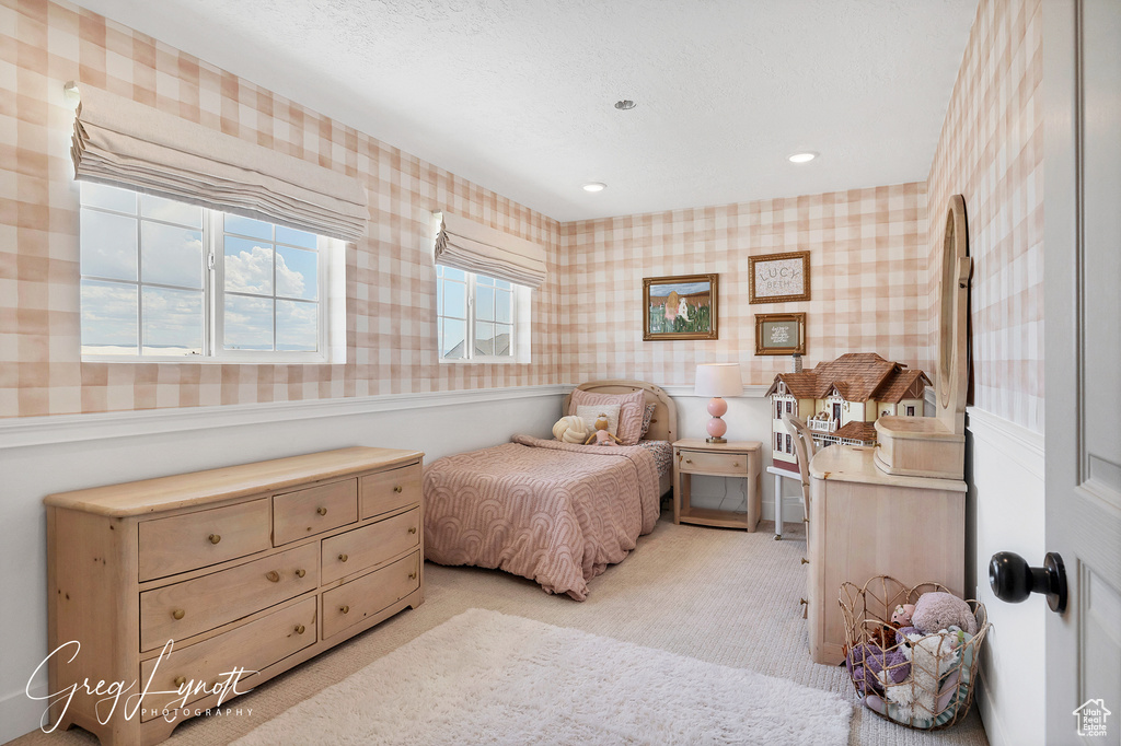 Bedroom with wallpapered walls, light colored carpet, a wainscoted wall, and recessed lighting