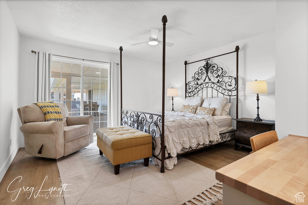 Bedroom with wood finished floors, access to exterior, and ceiling fan
