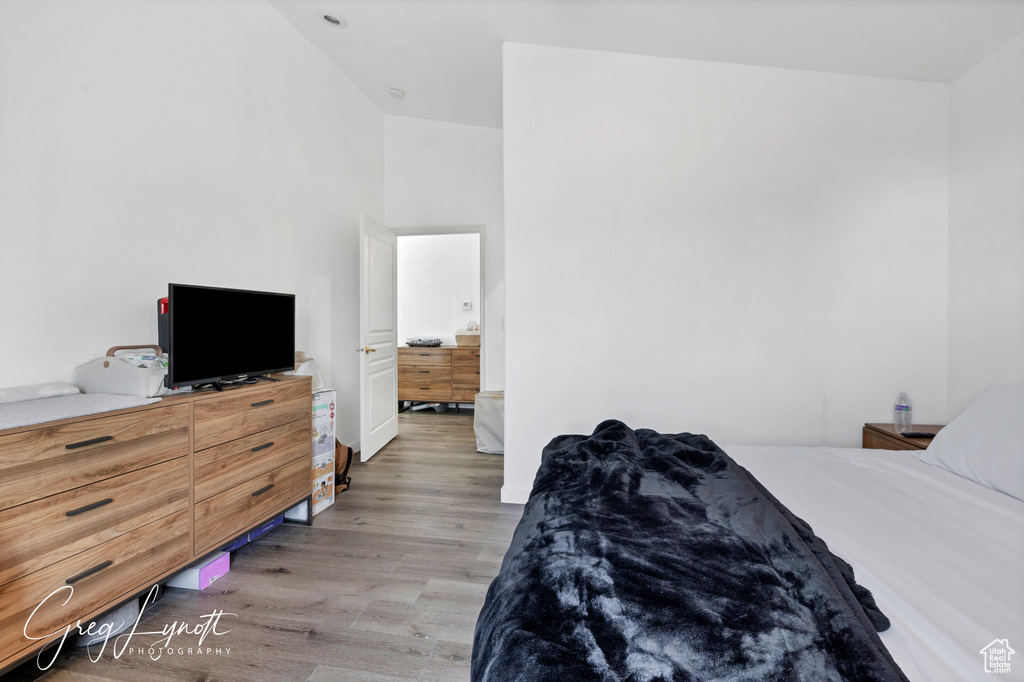 Bedroom featuring light wood finished floors and vaulted ceiling