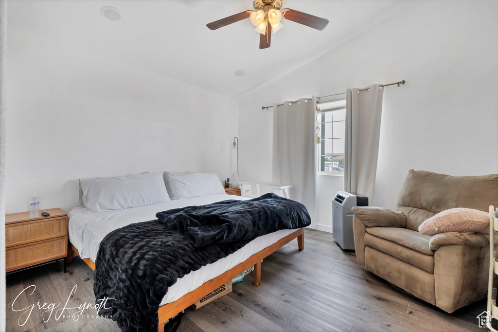 Bedroom with vaulted ceiling, wood finished floors, and ceiling fan