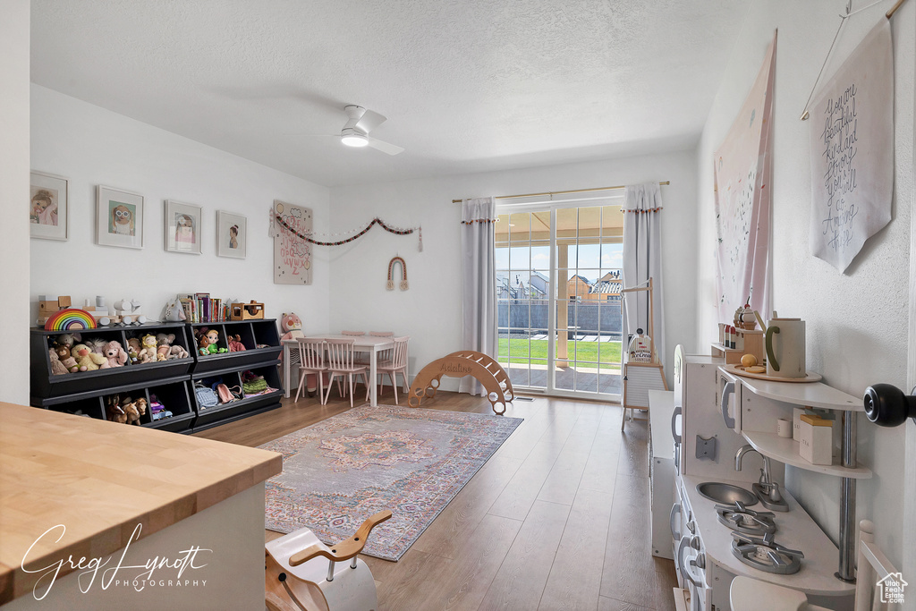 Living area featuring wood finished floors, ceiling fan, and a textured ceiling