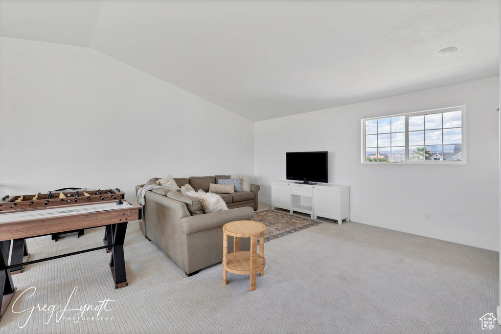 Carpeted living area with vaulted ceiling