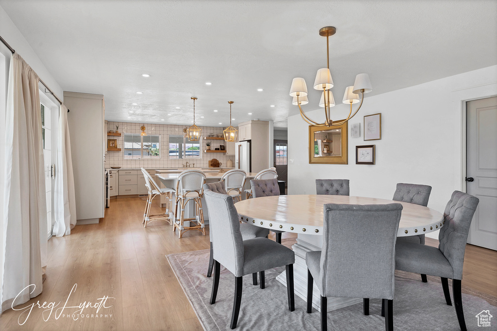 Dining room featuring a chandelier, light wood-style flooring, and recessed lighting