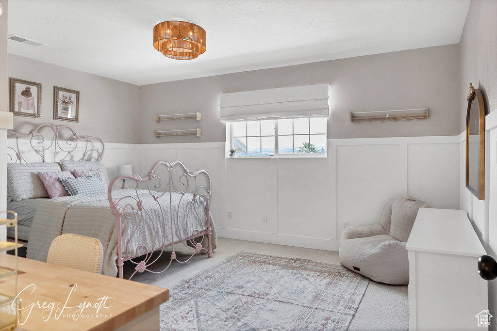 Bedroom with wainscoting and carpet flooring