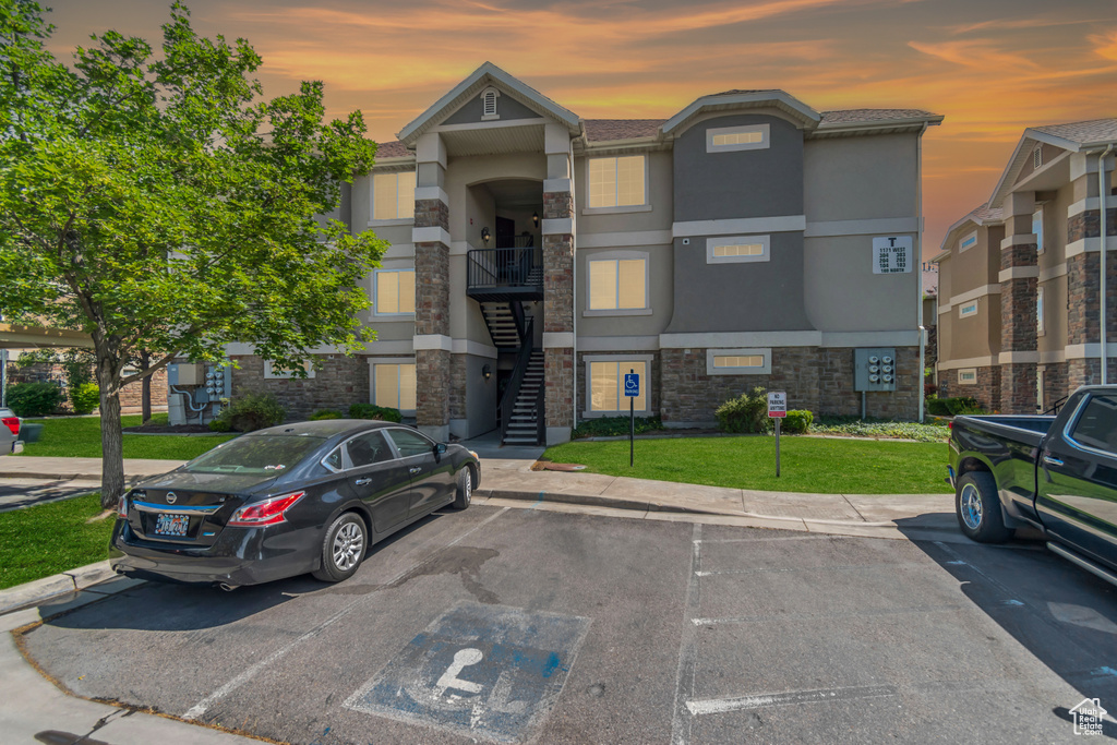 View of building exterior with uncovered parking and stairs