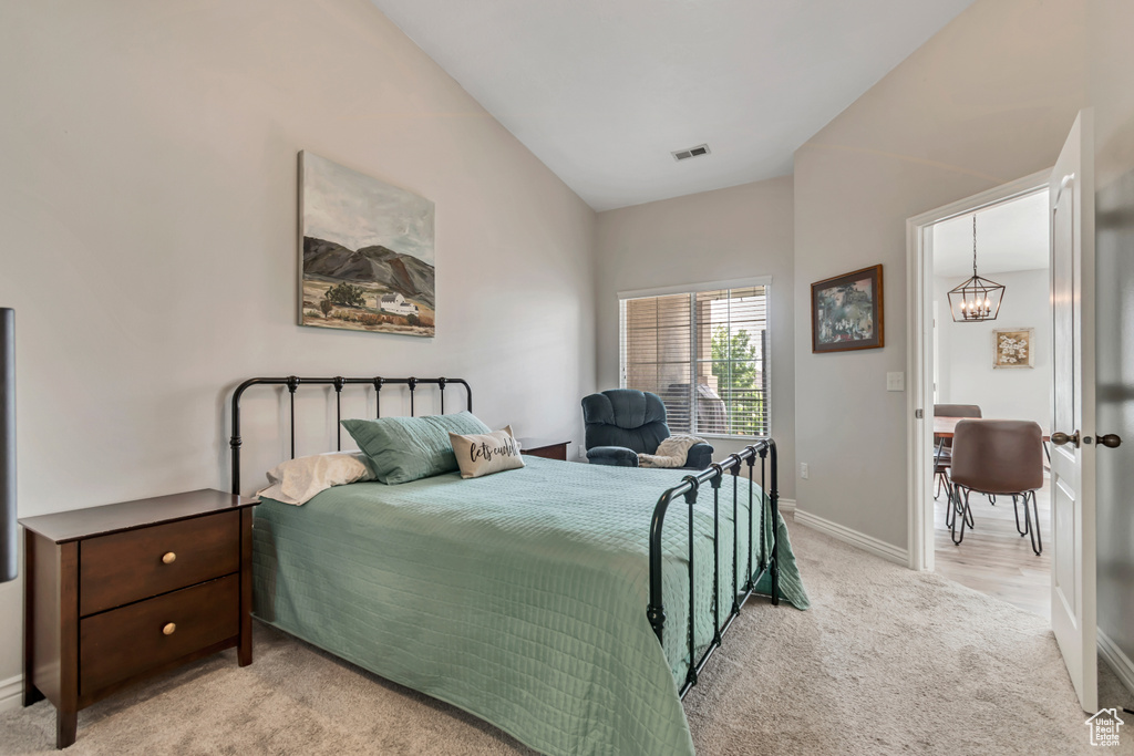 Carpeted bedroom with lofted ceiling and baseboards