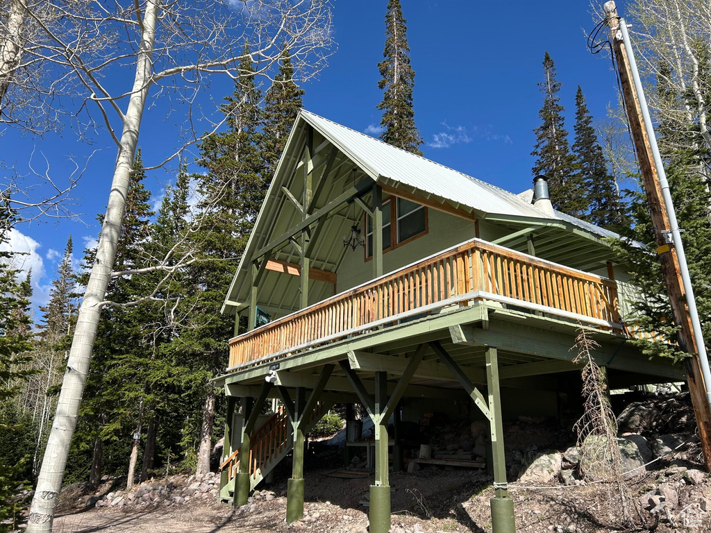 View of side of property featuring a wooden deck and a metal roof