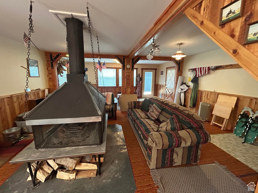 Rec room featuring a wainscoted wall, wooden walls, and a wood stove