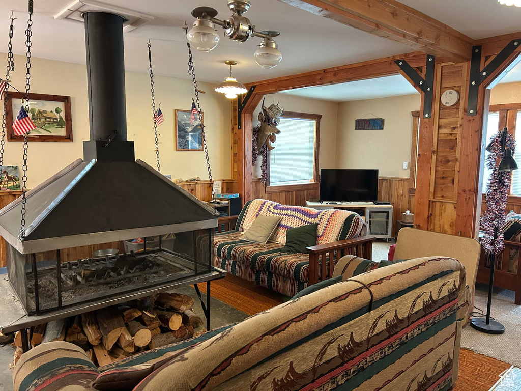 Carpeted living area featuring a wainscoted wall and wood walls