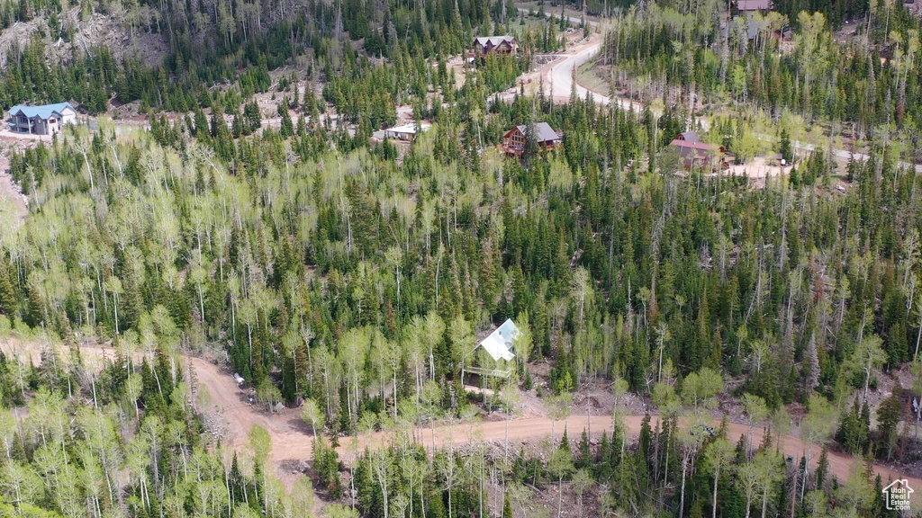 Aerial view of property and surrounding area featuring a heavily wooded area