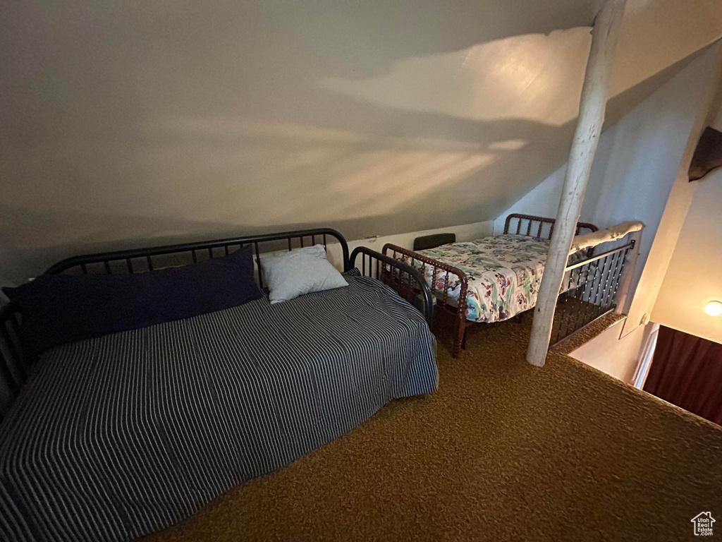 Carpeted bedroom featuring vaulted ceiling