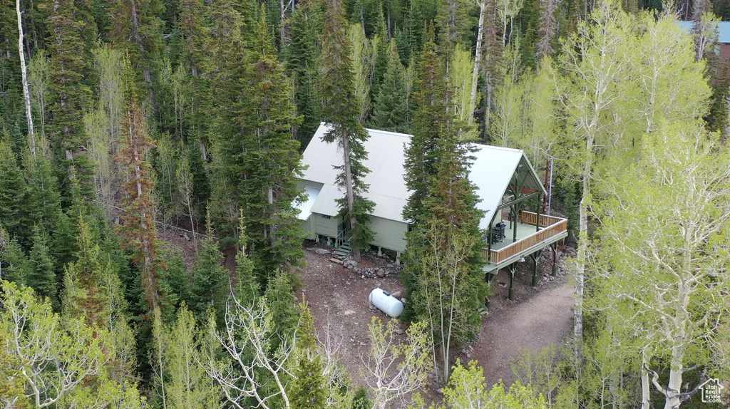 Aerial view of property and surrounding area with a forest