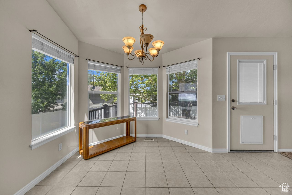 Unfurnished sunroom featuring a chandelier