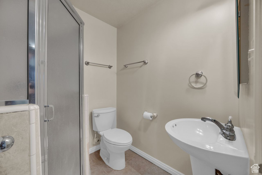 Bathroom with a shower stall and tile patterned flooring