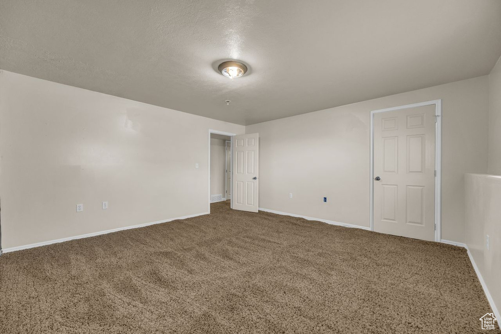 Unfurnished room with carpet and a textured ceiling