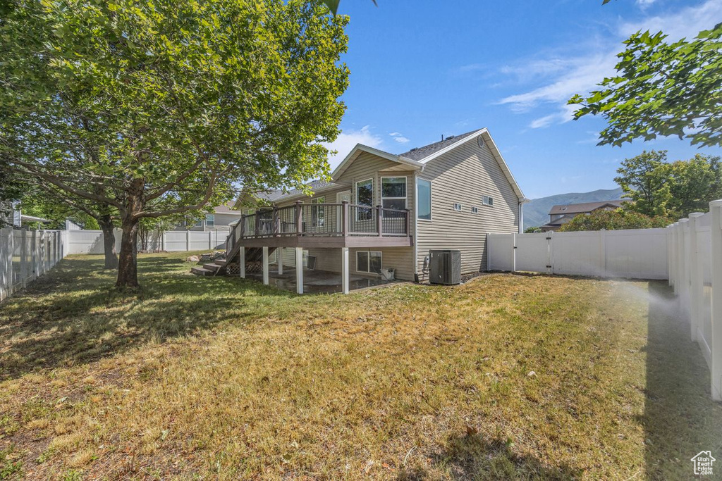 Rear view of house with stairs, a fenced backyard, and a wooden deck