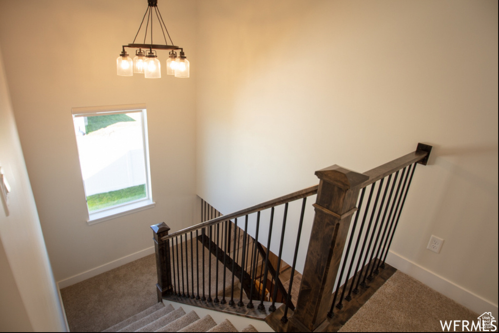 Staircase with carpet floors and baseboards