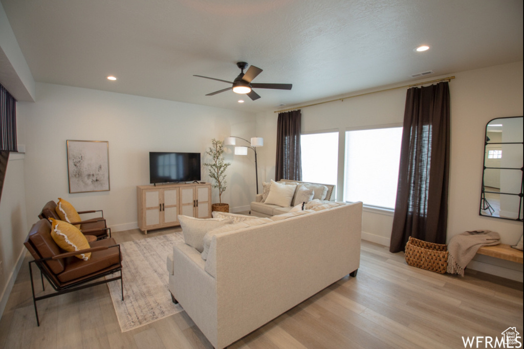Living area with light wood finished floors, a ceiling fan, and recessed lighting