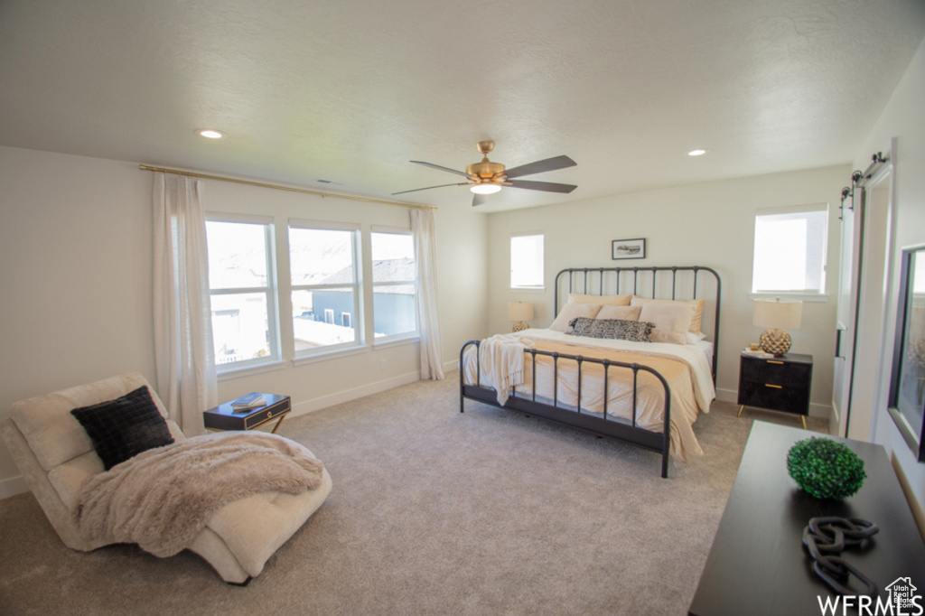 Carpeted bedroom with recessed lighting, a ceiling fan, and a barn door