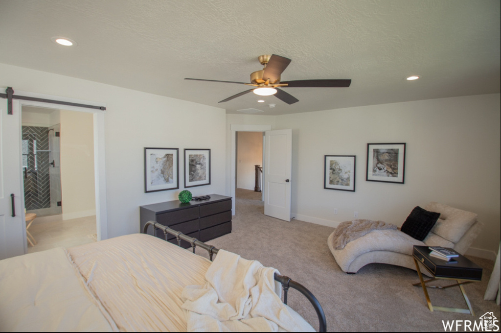 Bedroom with recessed lighting, light colored carpet, a barn door, ceiling fan, and a textured ceiling