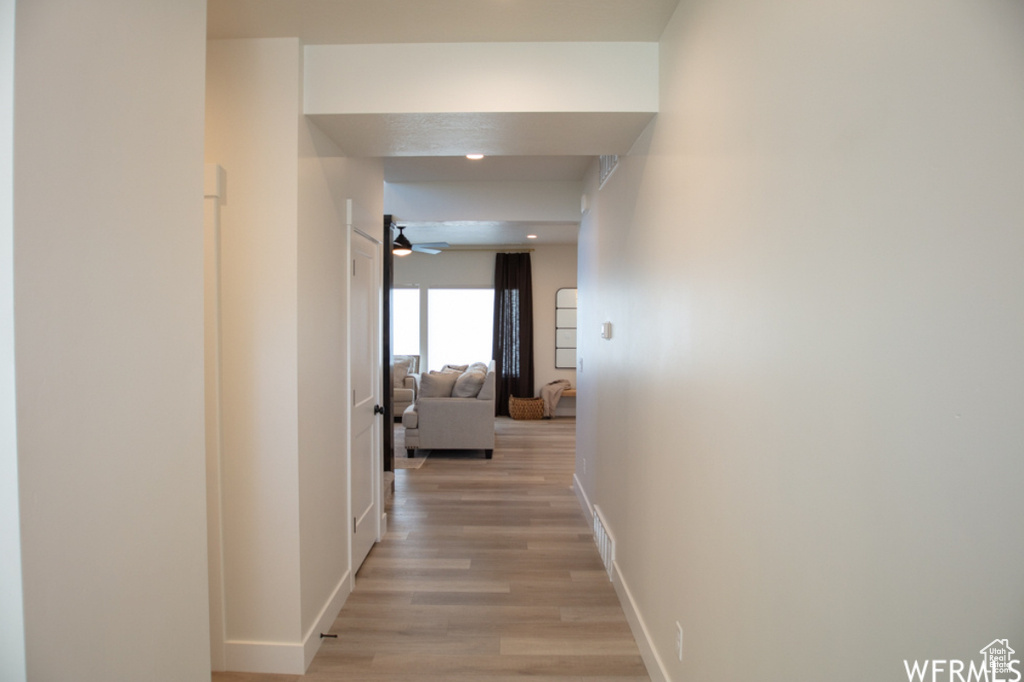 Hallway featuring light wood-style floors and baseboards