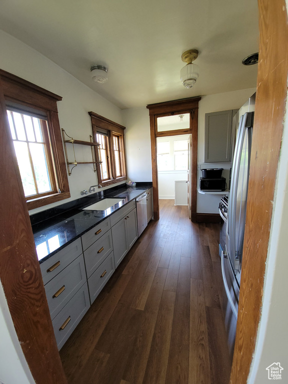 Kitchen featuring gray cabinetry, dishwasher, dark wood-style floors, and open shelves