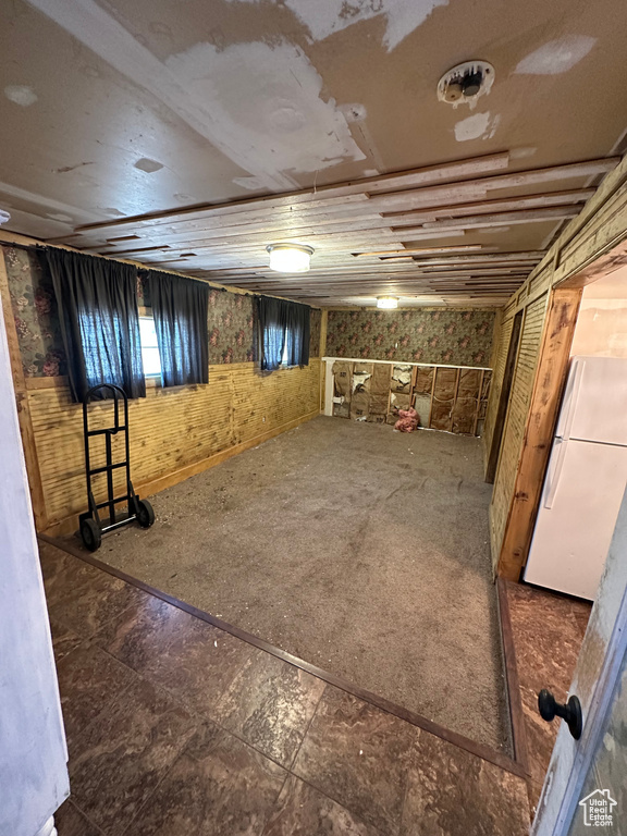 Below grade area featuring freestanding refrigerator