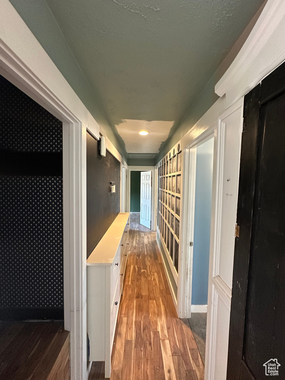 Hall featuring hardwood / wood-style flooring and baseboards
