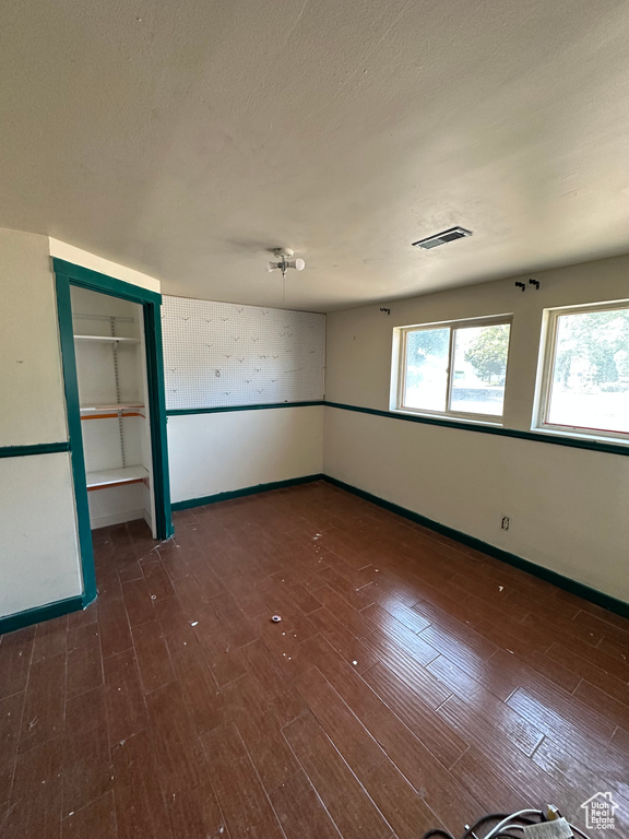 Empty room with healthy amount of natural light and wood finished floors